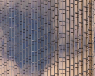 Blue sky and white clouds reflecting on rosegold facade